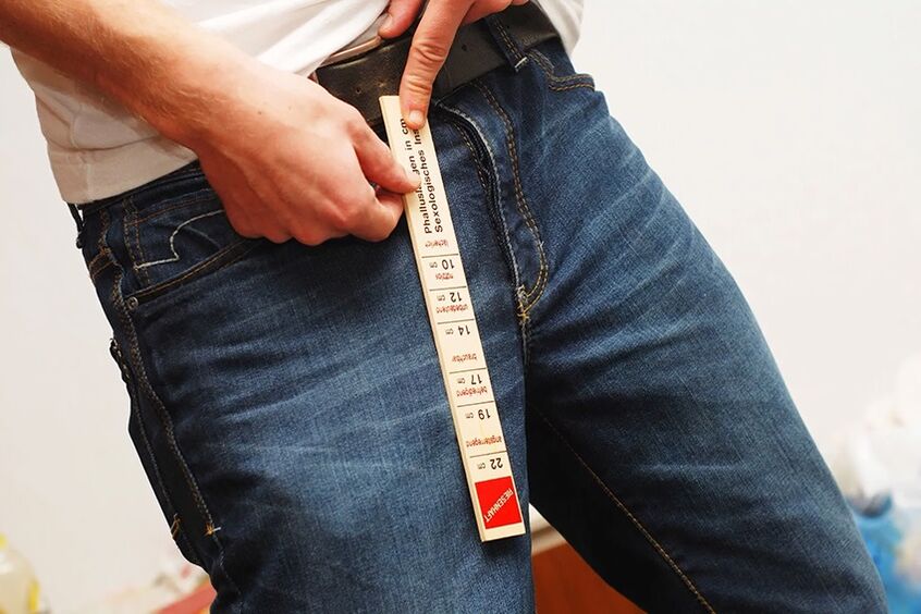拡大する前のペニスを測定する男性